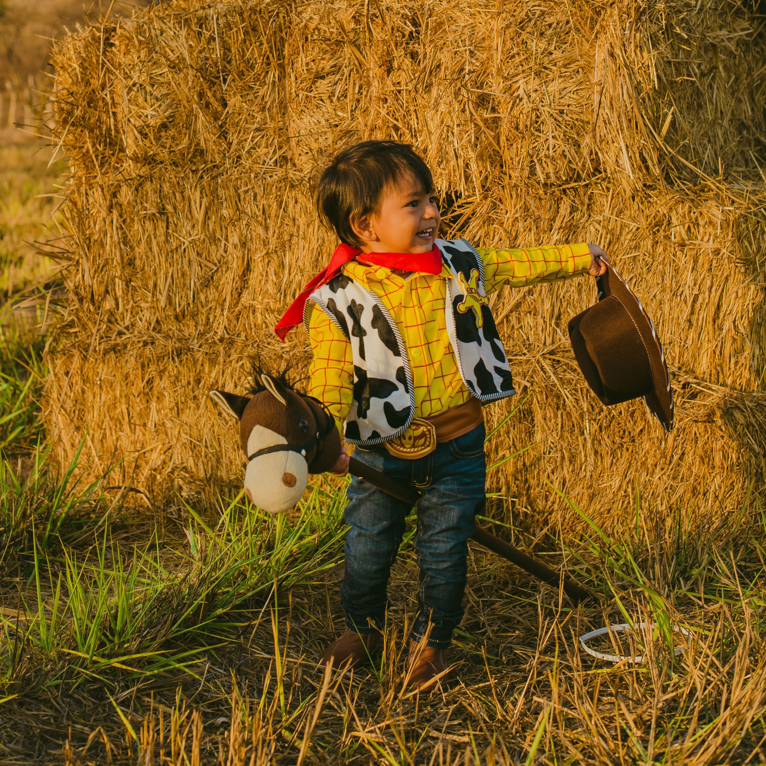 Junge als Cowboy verkleidet mit Stockpferd